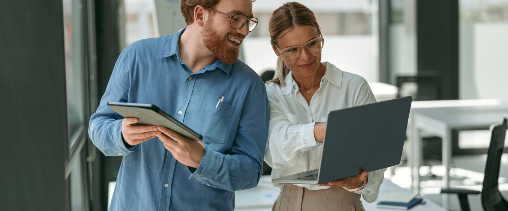 Two business colleagues working together on project in office while use laptop. High quality photo